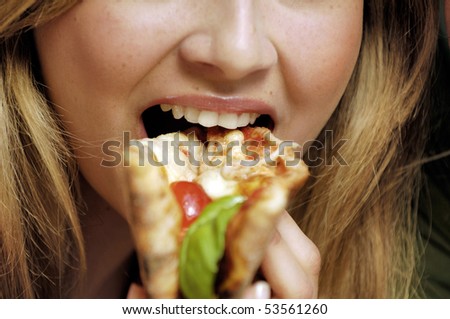 closeup of a woman eating pizza