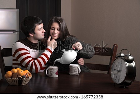 girl pours tea guy, while the guy stroking her face