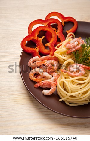 On a wooden table, eat cooked spaghetti with prawns