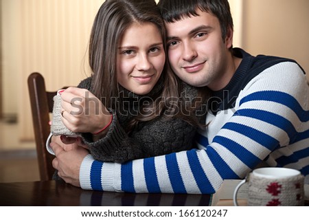 man hugs a woman that drinks tea