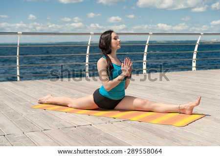 Yoga on the background of the sea. Pose cross twine