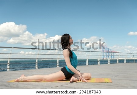 Yoga on the background of the sea. Pose cross twine