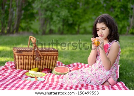 child peeling orange at picnic