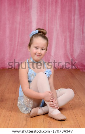 little ballerina girl sitting on stage