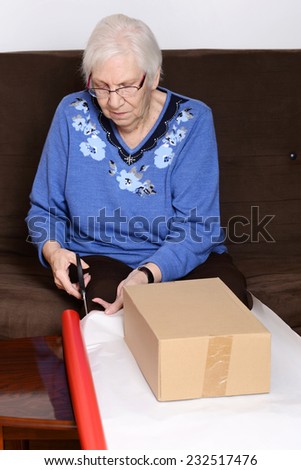 senior woman cutting christmas paper