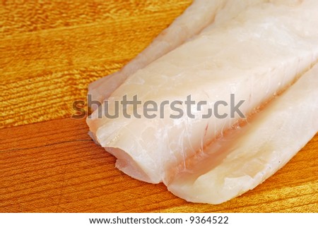 Raw Cod on a wooden butcher block