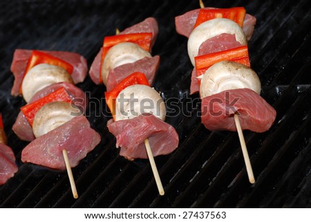 Uncooked beef kabobs on a barbecue 