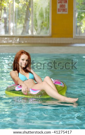 Young Woman Floating In Swimming Pool