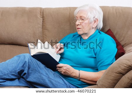 Senior Woman Turning Pages Of A Book