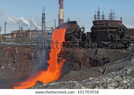 The molten steel is poured into the slag dump. The molten slag is poured from a bucket mounted on a railway platform.