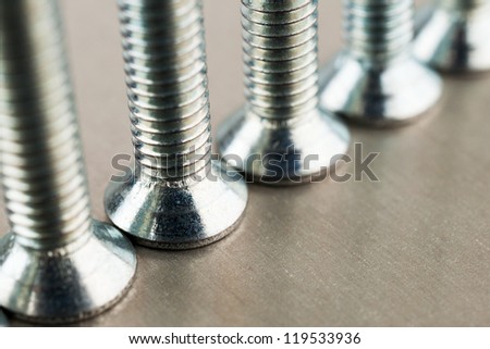 An even number of heads of metal bolts standing on a metal sheet