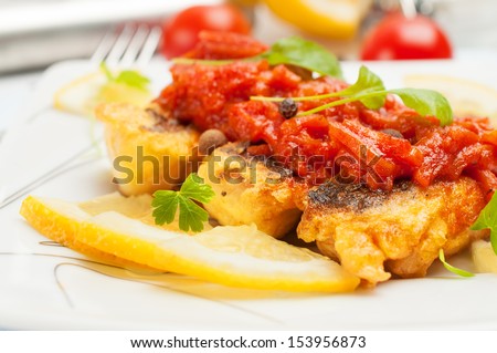 Fried fish with vegetable sauce. Closeup photo.
