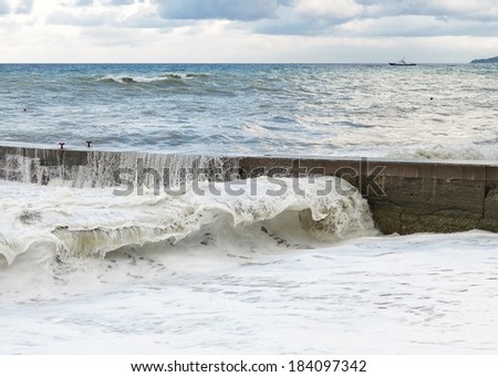 Storm waves roll on the concrete breakwater.