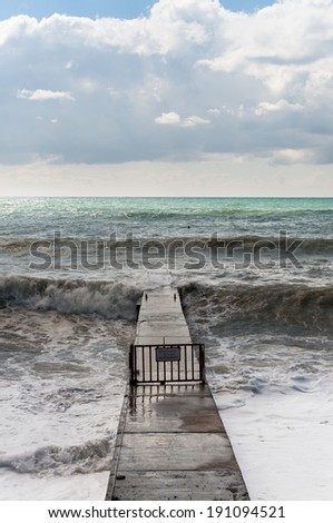 Storm waves roll on the concrete breakwater.