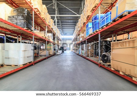 Large hangar warehouse industrial and logistics companies. Long shelves with a variety of boxes and containers.
