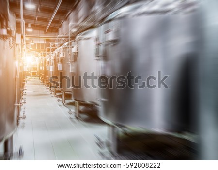 Modern Beer Factory. Rows of steel tanks for beer fermentation and maturation. Motion blur effect, sunlight