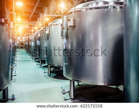 Modern Beer Factory. Rows of steel tanks for beer fermentation and maturation. Spot light effect