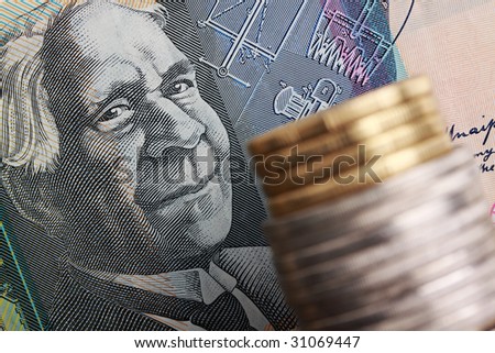 Australian $50 note with coins stacked in foreground. Focus on face of David Unaipon, aboriginal writer and inventor.