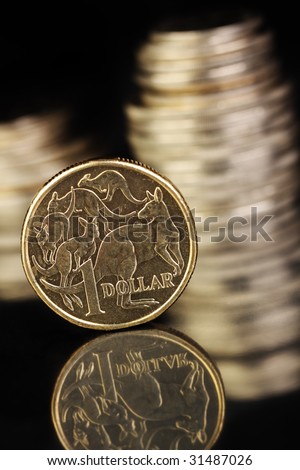 Australian $1coin on a dark reflective surface. Various aussie coins in the background.