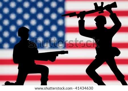 Two toy soldiers battling on an American flag background.