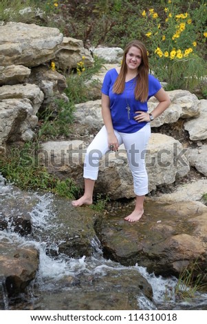 Young woman standing near rushing water attraction at Stephen\'s Lake Park in Columbia, Missouri