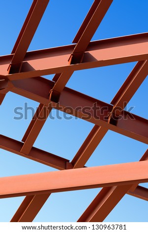 Steel beams against the blue sky. Fragment construction site.
