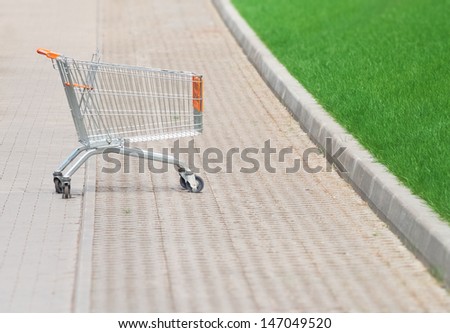 Shopping cart in the parking lot next to a supermarket
