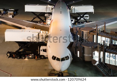 Airplane at gate during delivery catering service at night