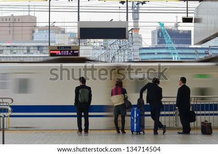 Group of business people waiting at shinkansen train platform, Japan