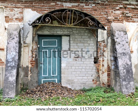 Ruins of an old smithy. Broken and damaged doors, wall.