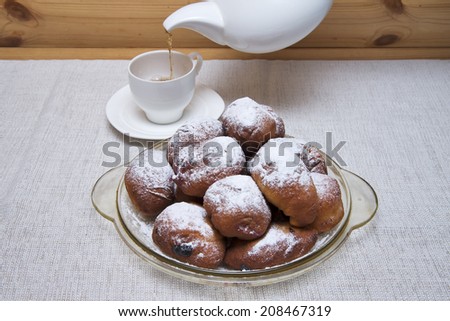 Donuts stuffed with currants. Traditional tea. Tea is poured into the cup.