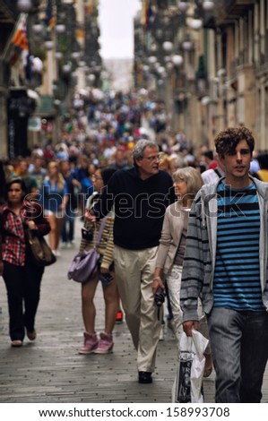 BARCELONA, SPAIN - SEPTEMBER 15: Close view of people walking at the street on September 15, 2013 in Barcelona. The crowd is at the street in Ciutat Vella.
