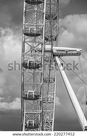 LONDON -  AUGUST 31, 2014: Tourists riding the London Eye. Side view of the London eye with people inside the pods. ItÃ?Â´s a famous tourist attraction over river Thames, providing great views of London.