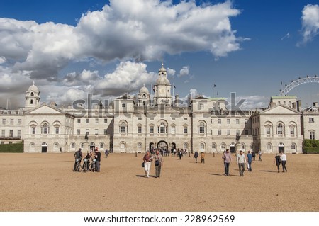 LONDON - AUGUST 31, 2014: Horse Guards building with people around it and the London Eye ferris wheel in the background.