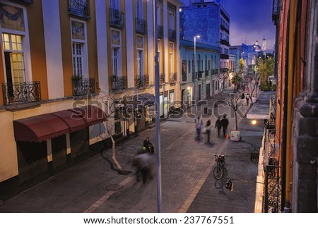Night in Mexico City. Streets of the center with blurred people, bars, restaurants and cafes.