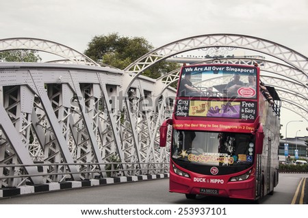 SINGAPORE - MAY 17, 2014: Double decker Red city touristic bus downtown with people inside.