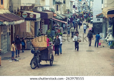 RABAT, MOROCCO - MAY 24, 2014: People at the streets of old town Medina with many shops and cafes. It is an administrative city but very popular among tourists with famous historical architecture.