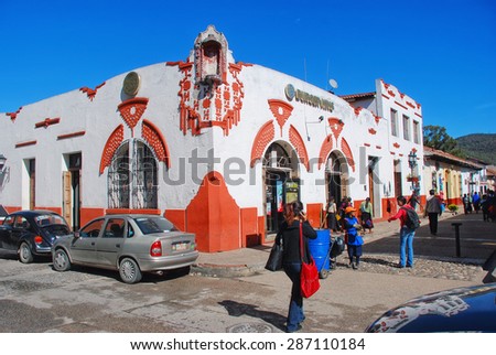 OAXACA, MEXICO - MARCH 18, 2011: Streets of colonial town with cars and people. Burger King in the old colorful building with white and orange walls