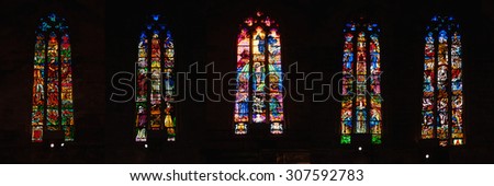 PALMA DE MAJORCA, SPAIN - JULY 13, 2011: Interior colorful windows of Gothic Roman Catholic Cathedral La Seu on dark background. Different religious paintings at the famous city landmark