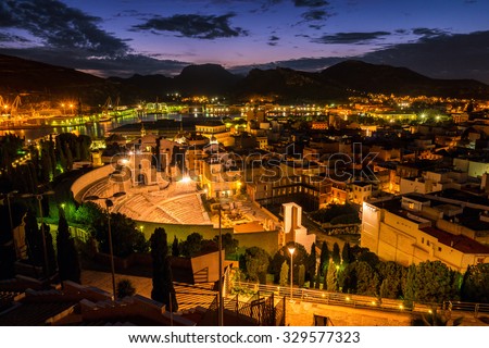 Aerial view of port city Cartagena in Spain with famous roman amphitheater. Beautiful sunset over the mountains.