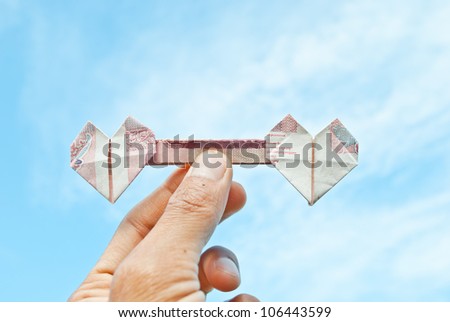 heart money in hand on blue sky background