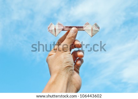 heart money in hand on blue sky background