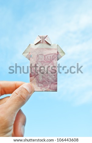 T shirt money in hand on blue sky background