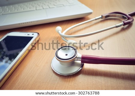 medical concept of Stethoscope , computer,smart phone on working table / vintage color