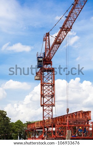 Industrial construction: red crane against blue sky
