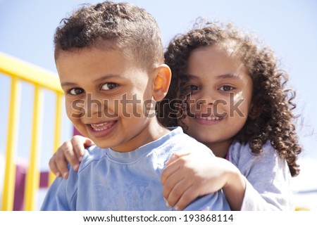 mixed race brother and sister hugging and smiling