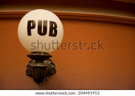 pub sign on light against wall