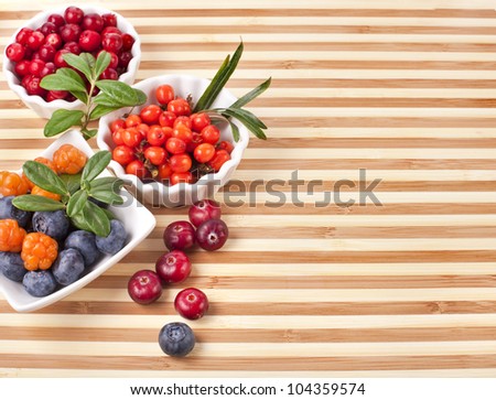 Fresh sweet berries in a wooden striped surface board texture background
