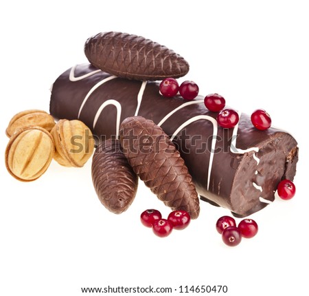 Chocolate swiss roll cake roulade with berries, nuts, choco cones isolated on white