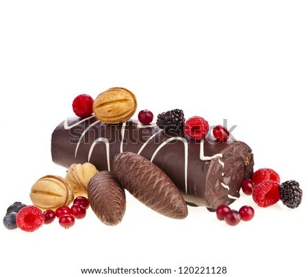 Chocolate swiss roll cake roulade with berries , nuts, cones isolated on white